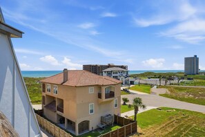 A multi-story residential building with a tiled roof, a balcony, and a view of the ocean. - La Mirage Condo 323 Beachfront Resort Condominiums with Private Boardwalk (Port Aransas)