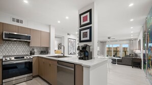 A modern kitchen with stainless steel appliances, a dishwasher, and a central island.