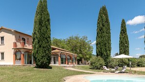 A villa with a swimming pool, a garden, and tall cypress trees. - Le Cascate by Interhome (Saturnia)