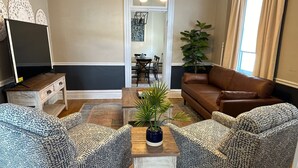 Een woonkamer met gestreept banken, een salontafel, een tv-meubel en een kamerplant.