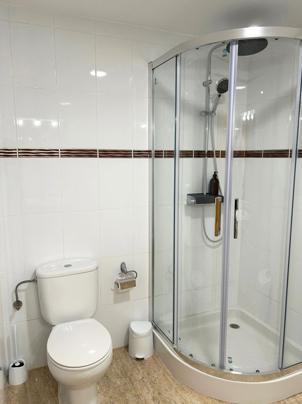 Un bany amb vàter, bidet, dutxa envidriada i terra emblaquenada.