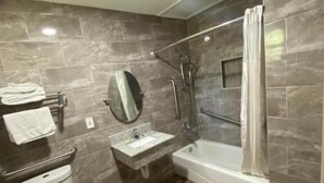A modern bathroom with a toilet, sink, and bathtub. - Red Carpet Inn (Daytona Beach)