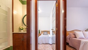 A hotel room with a bathroom, a bed, and a wooden wardrobe. - Tu y Yo by Interhome (Deltebre)