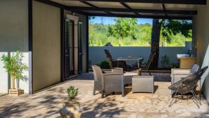 An outdoor patio with wicker furniture, a storage box, and a potted plant. - Vacation home Ulika by Interhome (Poreč/Baderna)