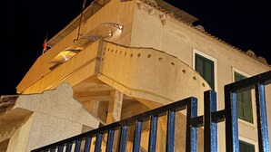 Un bâtiment doté d’un balcon, d’un escalier et d’une rambarde en métal.