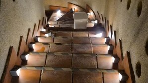 Un escalier au design original, avec des marches alternant entre des couleurs claires et foncées, et une rampe centrale.