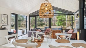 A modern dining area with a large table, white chairs, and a hanging rattan light fixture. - "Ela" - 800m from the sea by Interhome (Vig)