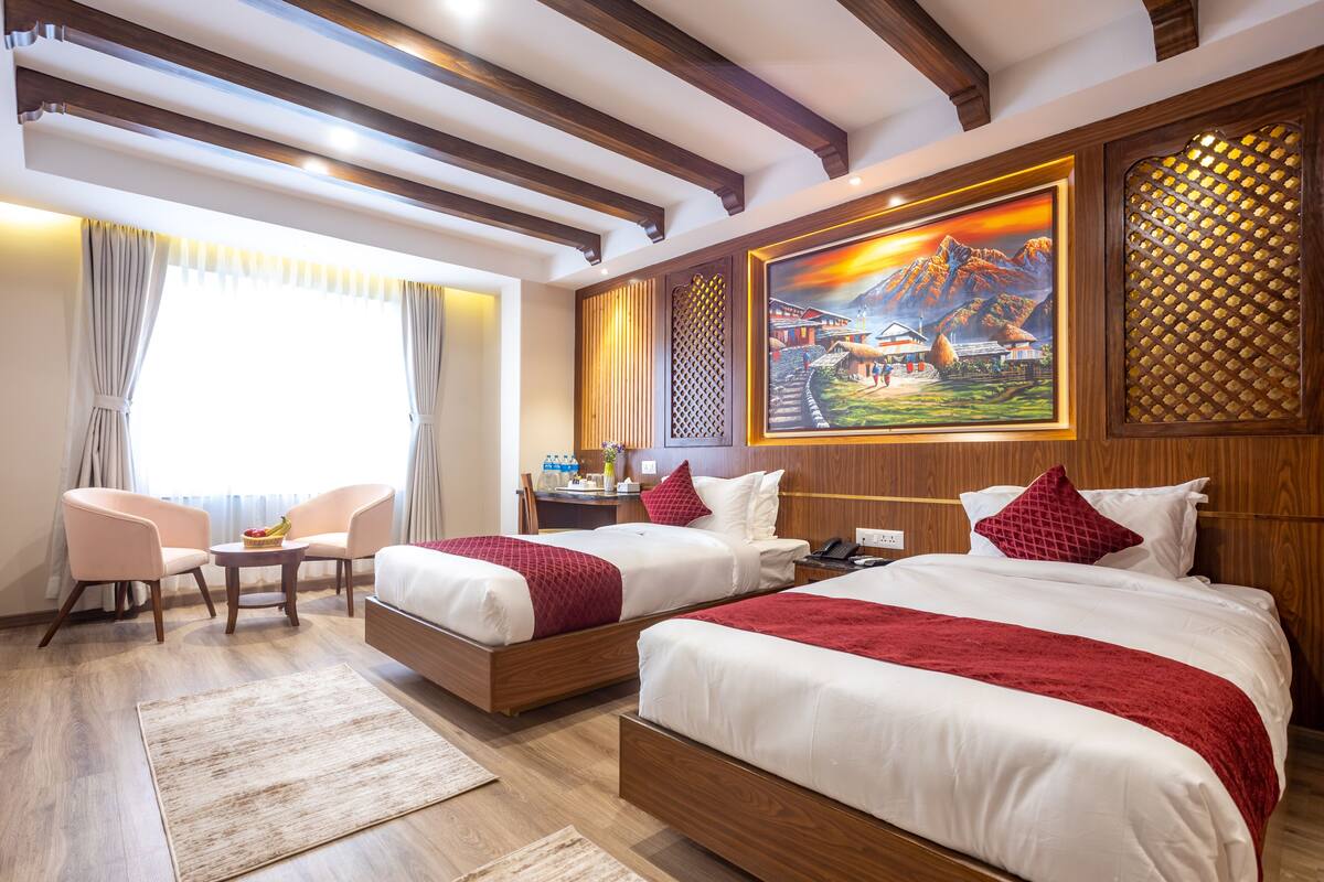 Ein Hotelzimmer mit zwei Betten, einem Schreibtisch und einem Stuhl.