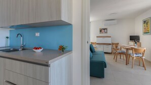 A modern kitchen with a sink, a bowl of tomatoes, and a vase of flowers. - Bel Horizonte 7, Capoliveri (Capoliveri)