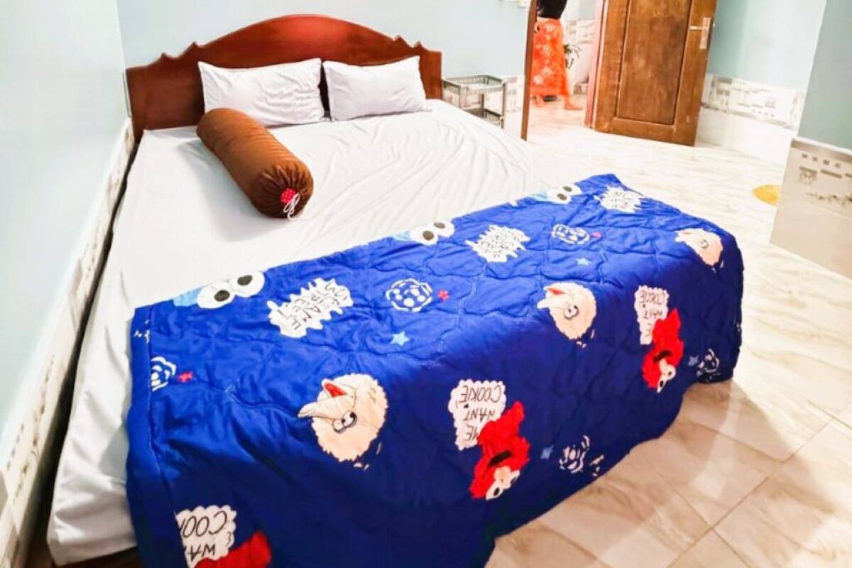 Une chambre à coucher avec un lit, un ventilateur de plafond et une porte.