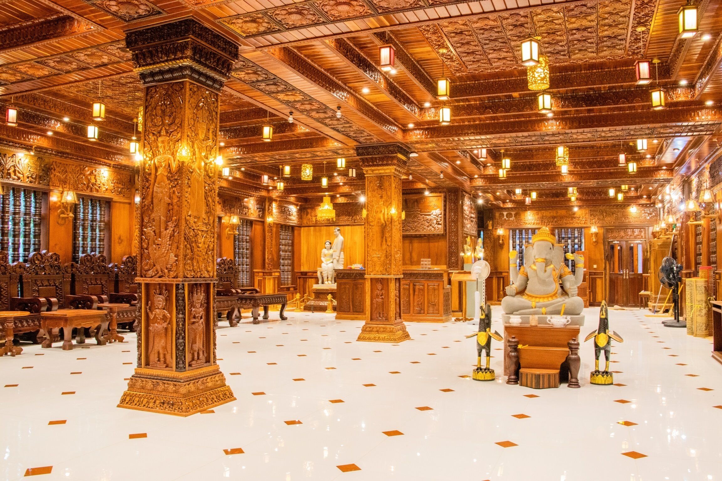 A spacious lobby with ornate columns, a central statue, and a polished floor.