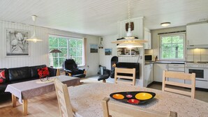A cozy living room with a sofa, a dining table with a tray of fruit, and a kitchen area with appliances. - "Ylvi" - 2.8km from the sea by Interhome (Rømø)