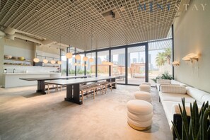A modern kitchen with a large island, ample seating, and large windows offering views of the city.