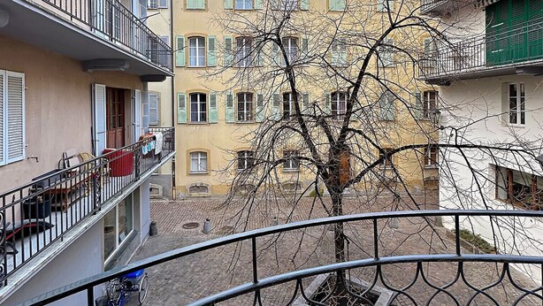 A courtyard with a tree, a bicycle, and a balcony railing. - Studio 505 - Sion Old City - Swiss Alps (Sion)