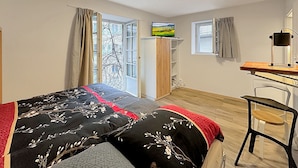 A bedroom with a bed, a desk, a chair, a wardrobe, and a window with curtains. - Studio 505 - Sion Old City - Swiss Alps (Sion)