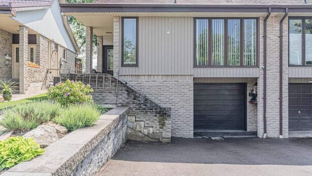 A modern two-story house with a stone facade, a covered porch, and a garage. - Mississauga 2BDR Lower Unit Parking Self-check in (Mississauga)