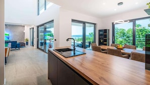 Une cuisine moderne dotée d’un plan de travail en bois, d’un évier et d’un coin repas avec une table et des chaises.