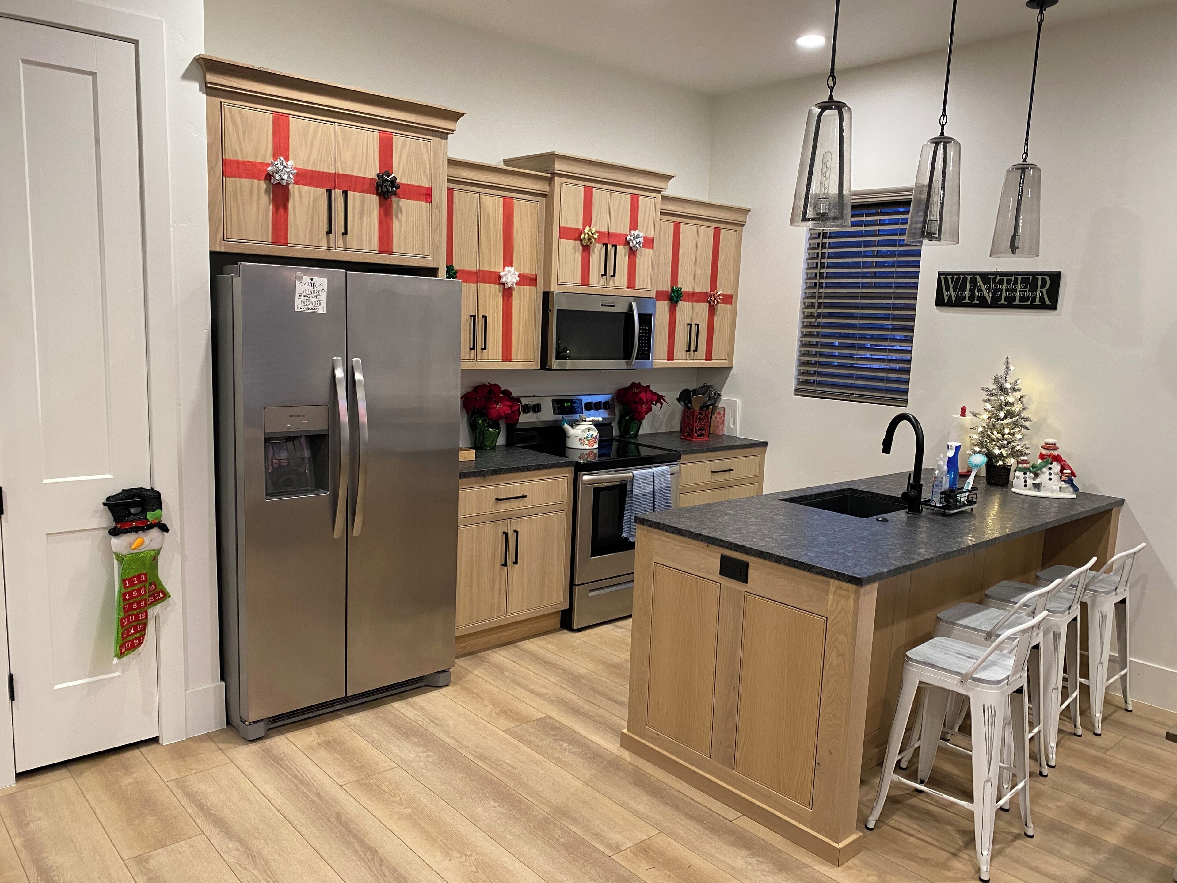 A modern kitchen with wooden cabinets, stainless steel appliances, and a central island.