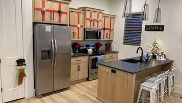 A modern kitchen with wooden cabinets, stainless steel appliances, and a central island.