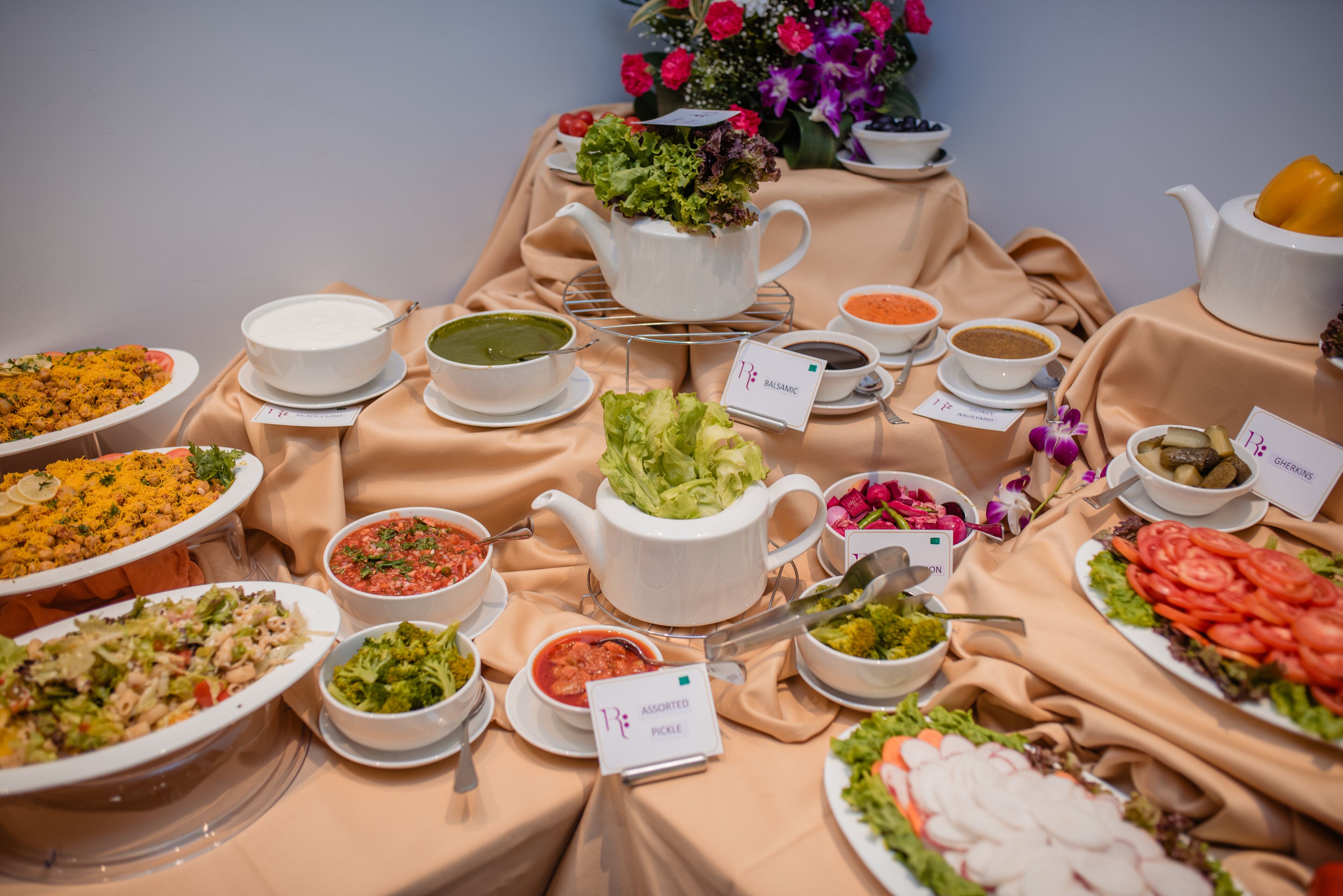Uma mesa de buffet com diversos pratos e um bule de chá.