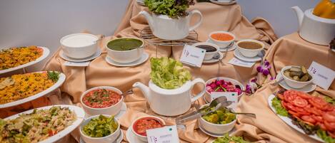 A buffet table with various dishes and a teapot.