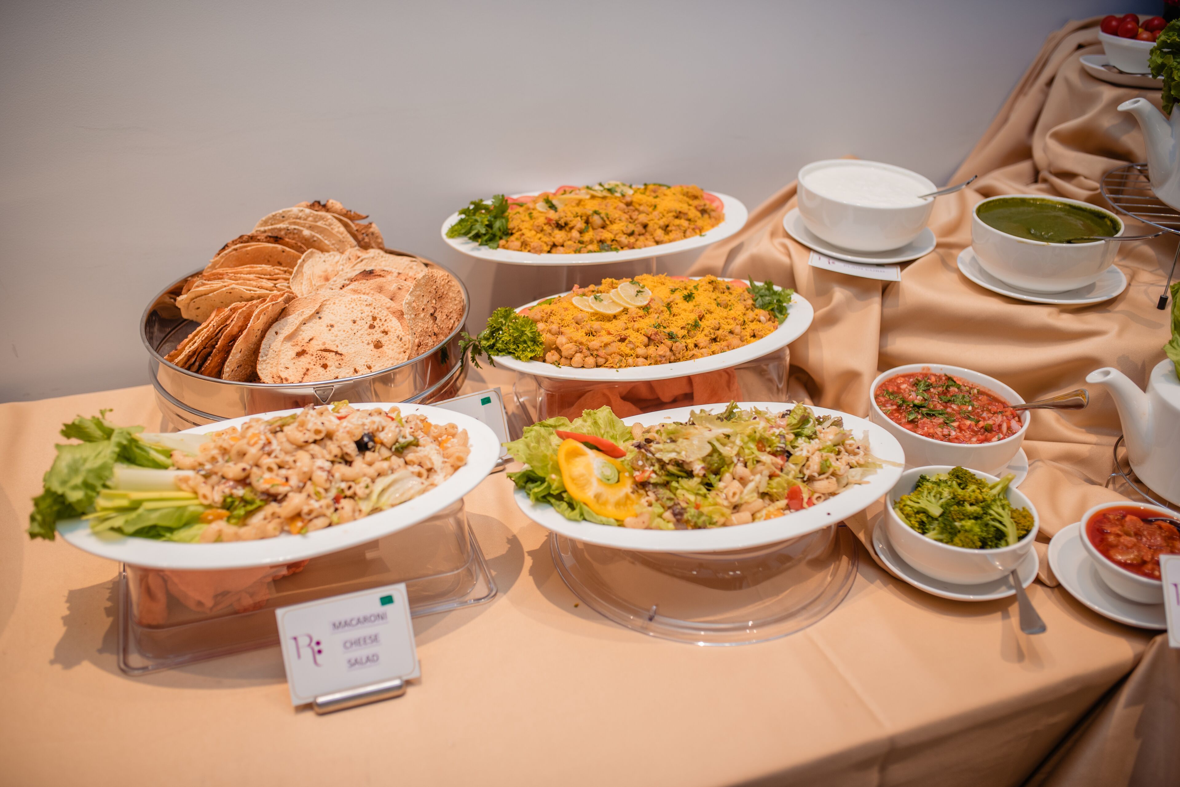 Una mesa de buffet con diversos platos, incluyendo pasta, ensaladas y pan.