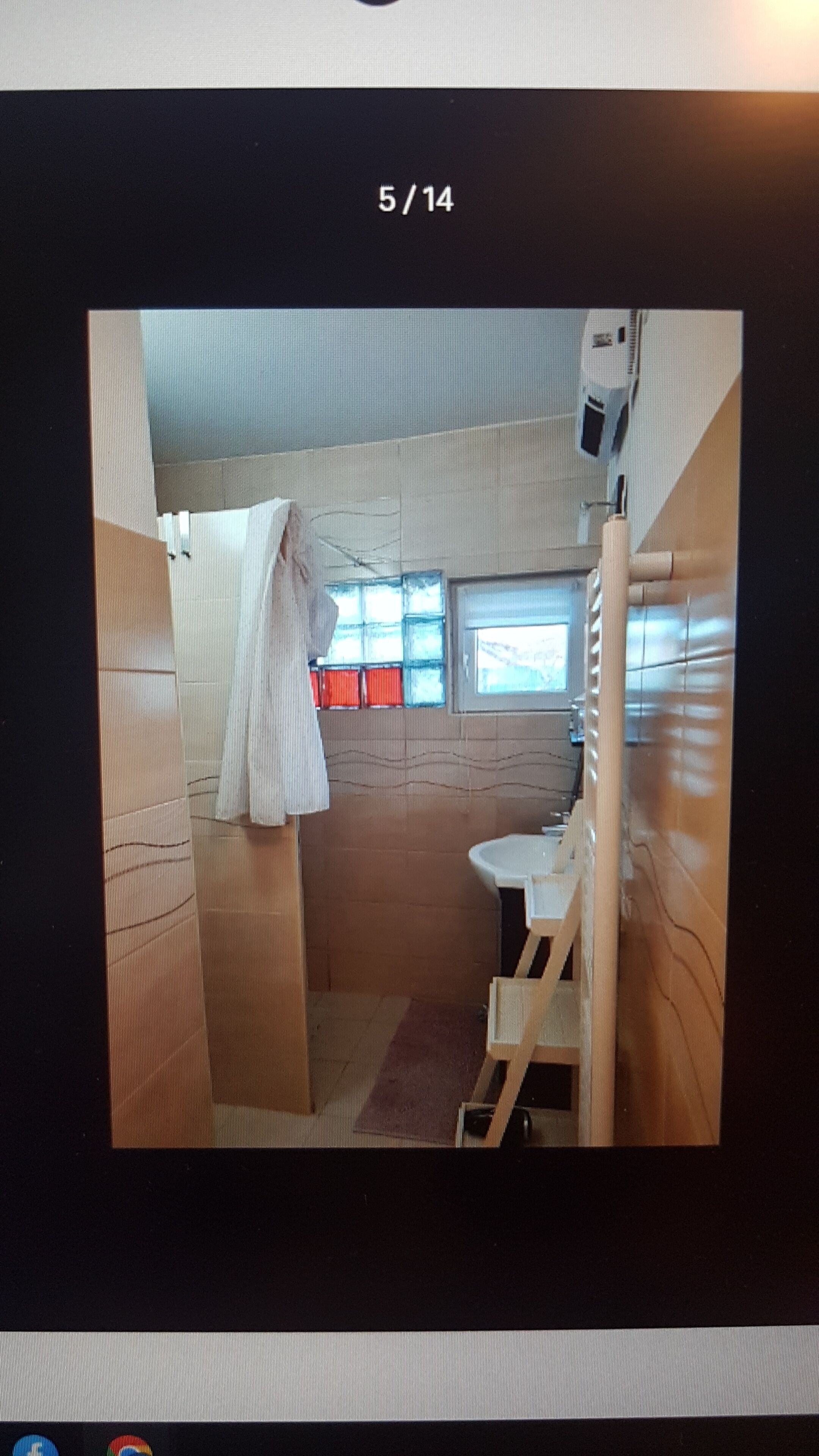 A compact bathroom with a shower, a sink, and a window.