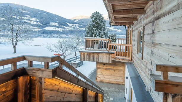 A wooden staircase leading to a balcony with a snowy landscape view. - Chalet in Neukirchen near Ski Arena Wildkogel (Neukirchen am Großvenediger)