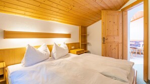 A neatly made bed with white linens and pillows, a wooden headboard, and a wooden ceiling. - Chalet in Mittersill near Ski Slopes (Mittersill)