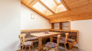 A cozy room with a wooden table and bench seating, a skylight, and a small shelf unit. - Chalet in Mittersill near Ski Slopes (Mittersill)