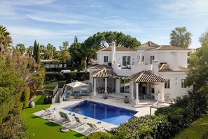 A large white villa with a swimming pool, outdoor seating, and a well-maintained garden. - Villa Grace - Quinta do Lago (Almancil)