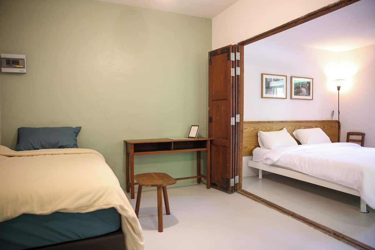 A room with two beds, a desk, and a chair.