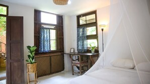 A bedroom with a bed, a desk, and two windows with curtains. - Baannoi Nornmuan Homestay Chiang Mai (Chiang Mai)