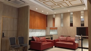 A modern interior with a seating area, wooden panel walls, and a ceiling with geometric patterns. - Mc Hotel Fairview (Quezon City)