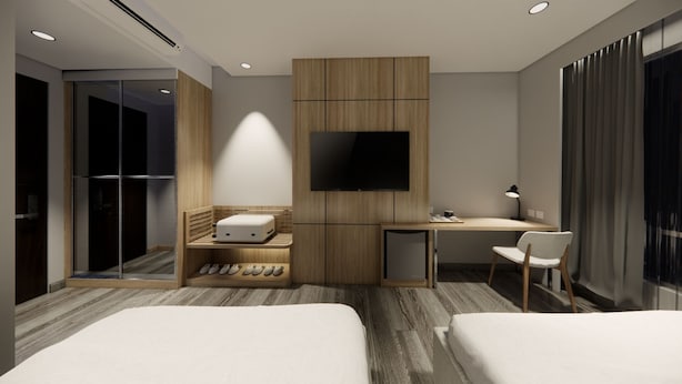 A modern hotel room with two beds, a desk, a TV, and a shoe rack. - Mc Hotel Fairview (Quezon City)