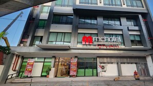 A modern hotel with a prominent 'mhotel' sign, large windows, and a visible entrance. - Mc Hotel Fairview (Quezon City)