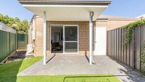 A covered patio area with a sliding glass door leading to a room. - Cosy Modern Home close to Fremantle (Coolbellup)