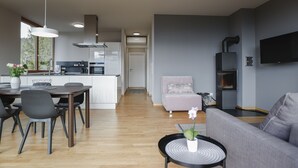 A modern living space with a dining area, kitchen, and seating area. - 100 m2 Penthouse mit 3 Schlafzimmer, Grosser Überdachter Terrasse und Bergblick (Klaus)