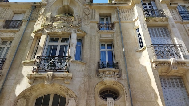 A historic building with ornate architectural details, including decorative balconies and arched windows.