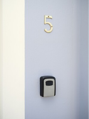 A wall-mounted number 5, a doorbell, and a mail slot. - 5 minutes from the beach spacious apartment for families and group of friends (Durrës)