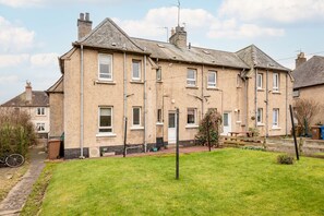 A two-story residential building with a front garden, a visible door, and a bicycle parked outside. - Boase Avenue (No 24) | St Andrews (St Andrews)