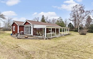 Une maison à deux étages dotée d’un patio couvert.