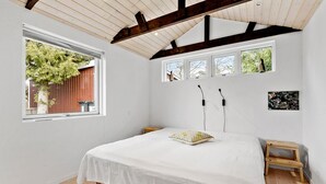 A bedroom with a bed, a window, a small table, and a wall-mounted picture. - 3 bedroom cozy home in Skibby (Skibby)