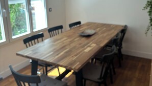 Un comedor con una mesa de madera, sillas negras y una lámpara colgante.
