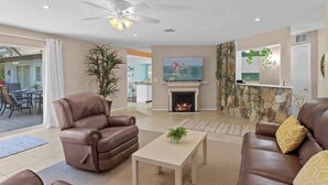 A spacious living room with leather sofas, a fireplace, a ceiling fan, and a television. - Heated Pool, 4BR & 3 Full Baths — 10 Min to AMI (Bradenton)