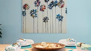 A dining table with a central decorative bowl, surrounded by white plates and bowls with blue placemats. - Heated Pool, 4BR & 3 Full Baths — 10 Min to AMI (Bradenton)