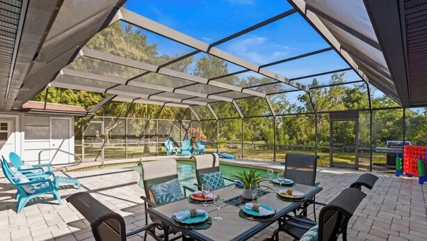 A covered patio with a pool, outdoor seating, and a grill area. - Heated Pool, 4BR & 3 Full Baths — 10 Min to AMI (Bradenton)