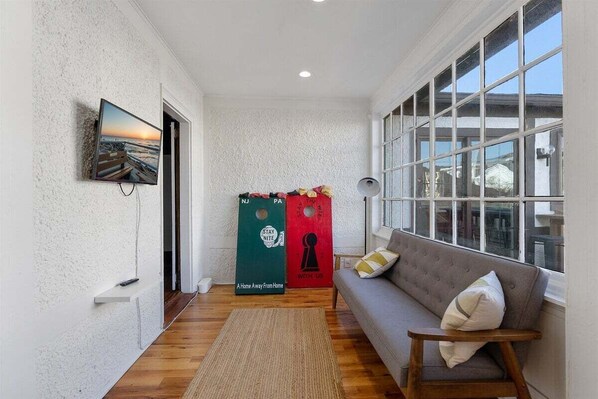 Una habitación acogedora con un sofá, un televisor en la pared y una ventana con vistas.