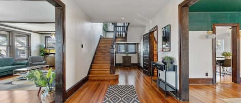 Un espacio habitable amplio con una escalera de madera, un comedor y vistas al exterior.