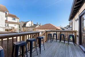 Eine Holzterrasse mit Barhocker mit Blick auf eine Wohngegend.